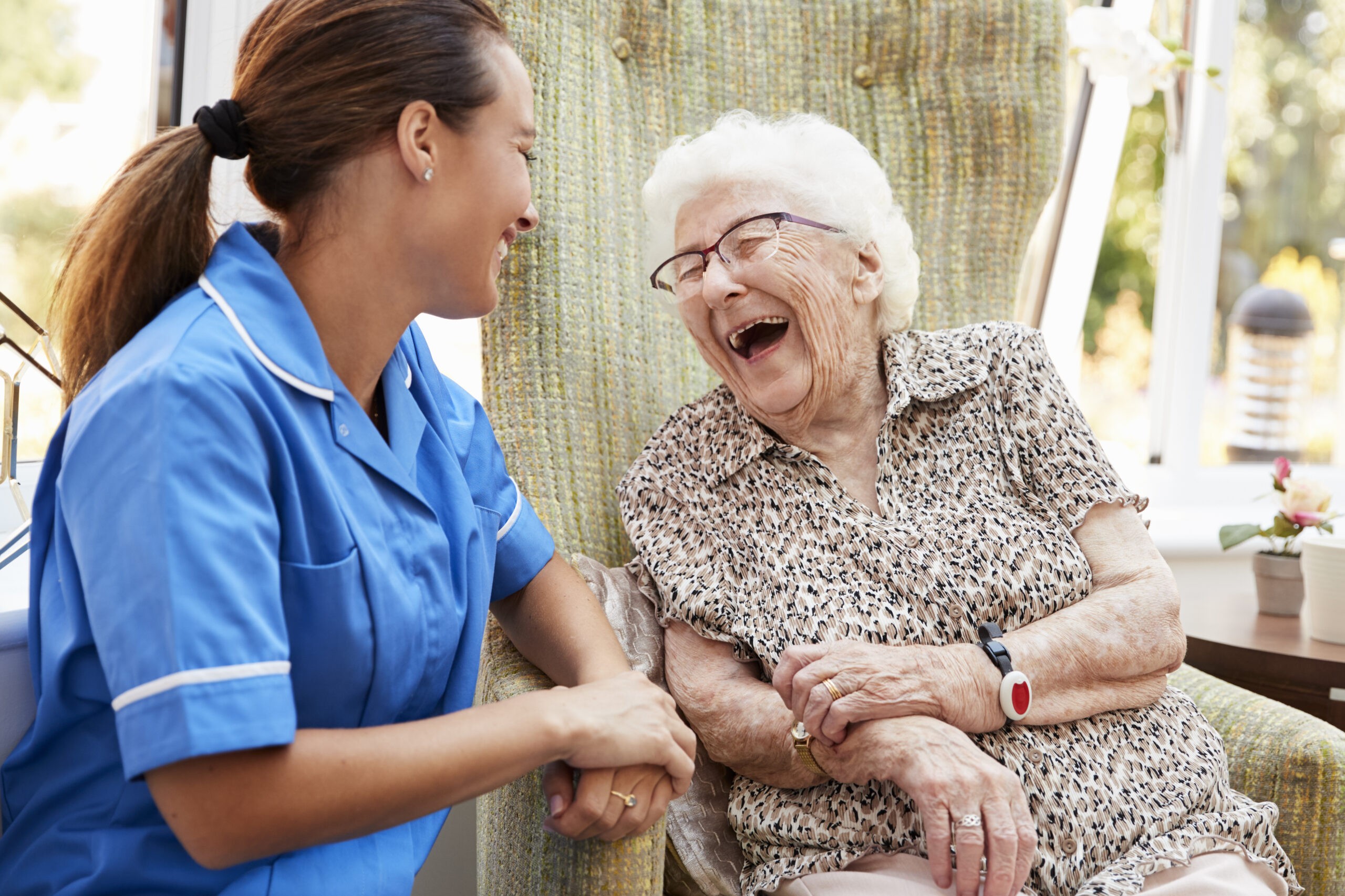 female healthcare provider making an elderly woman laugh