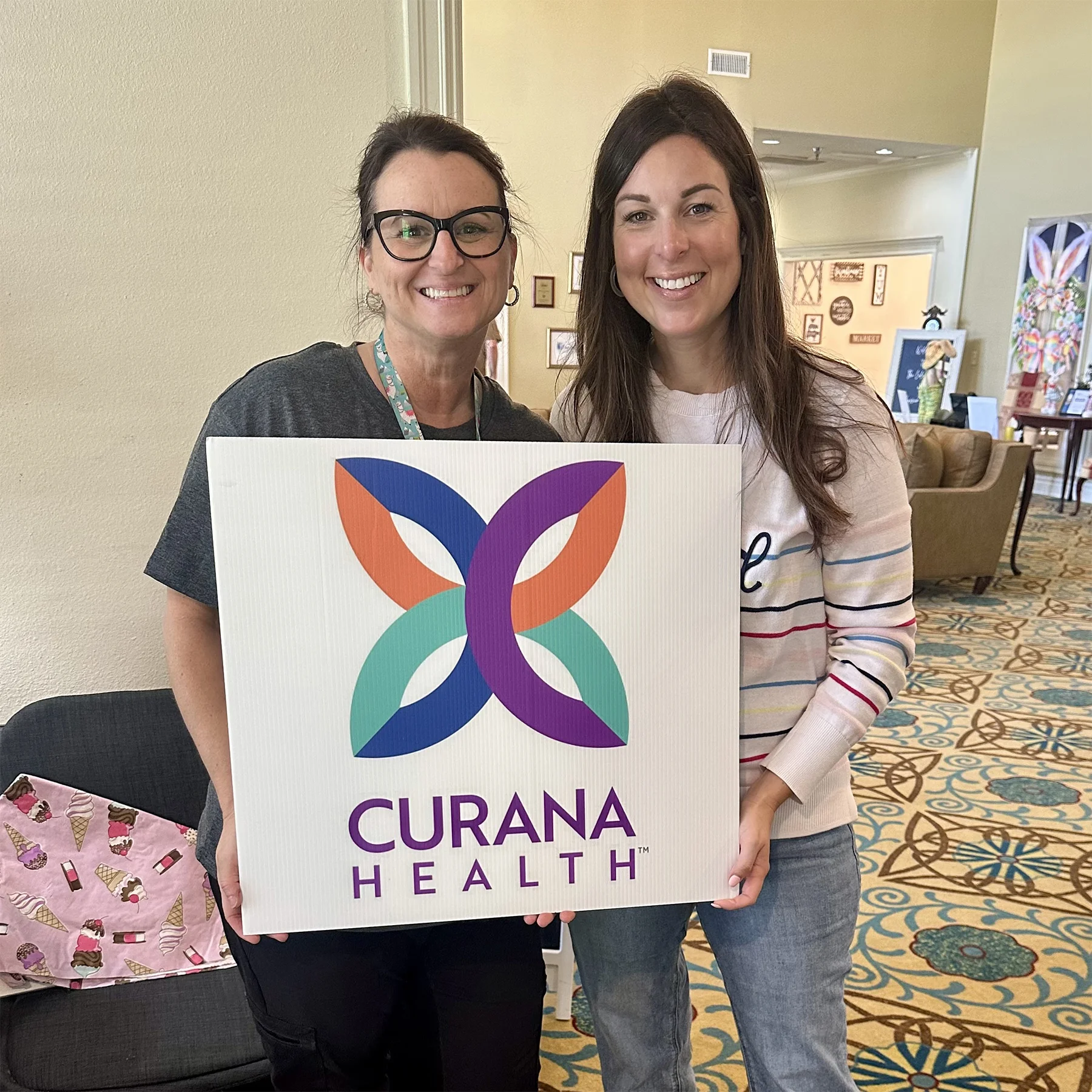 Curana team holding sign with logo
