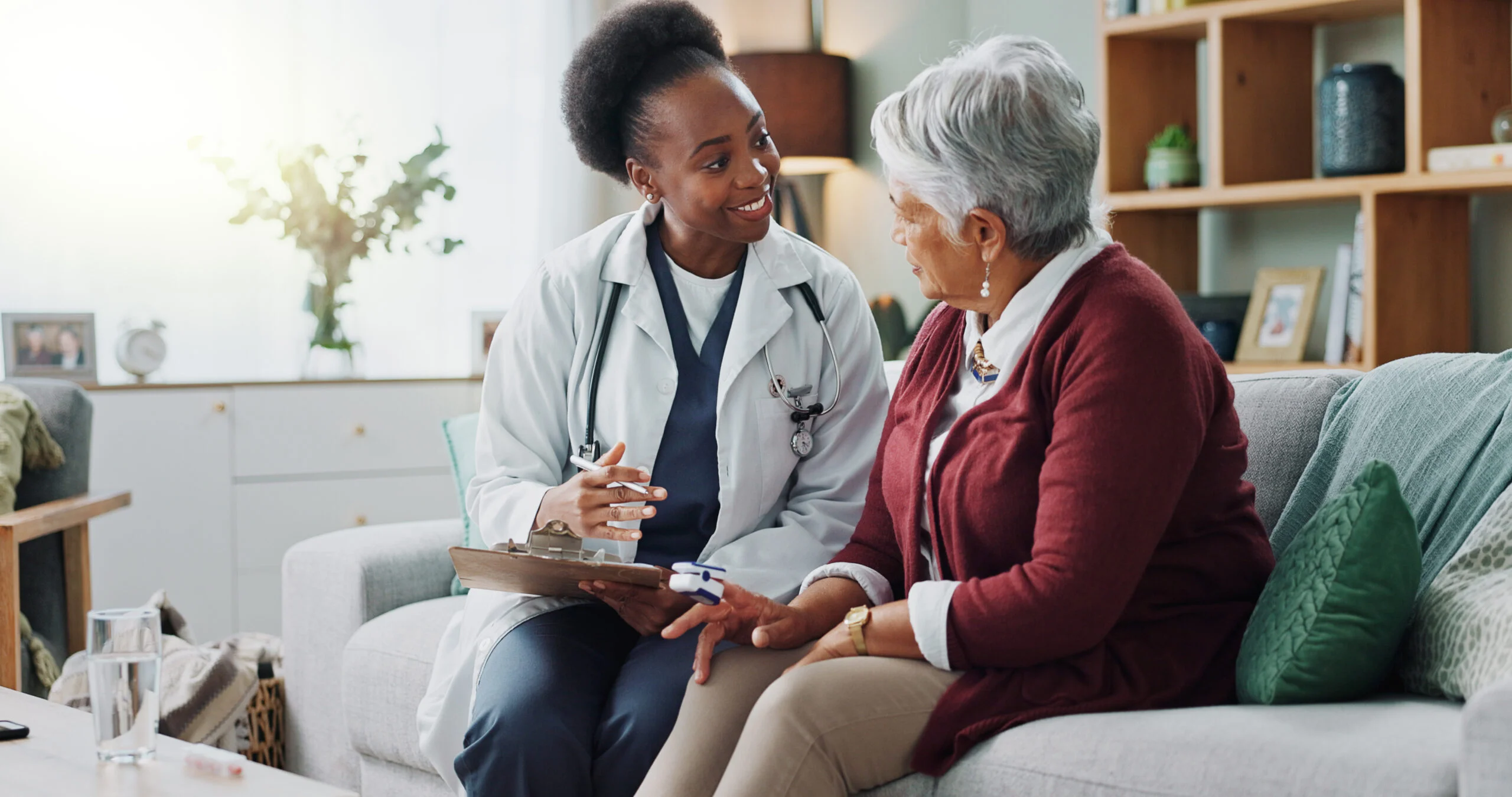 Doctor writing a senior patient's information onto a clipboard