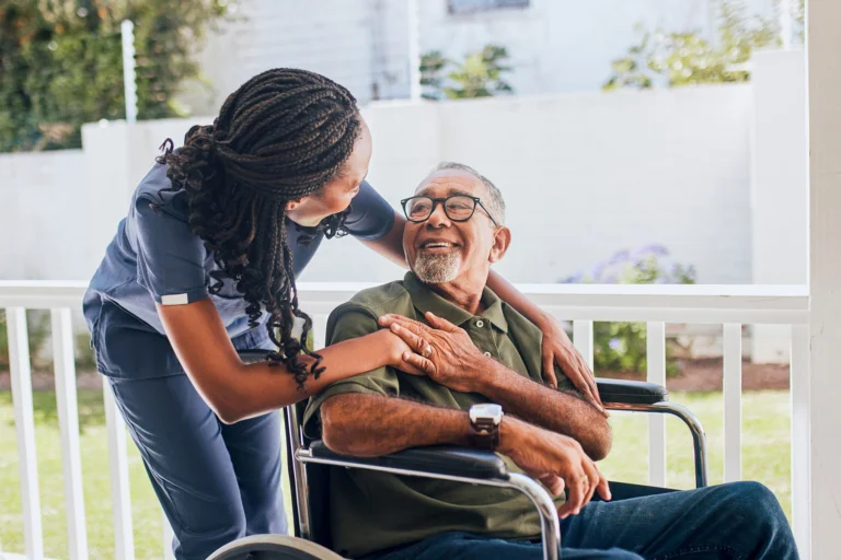 Senior in wheelchair looking appreciatively at nurse