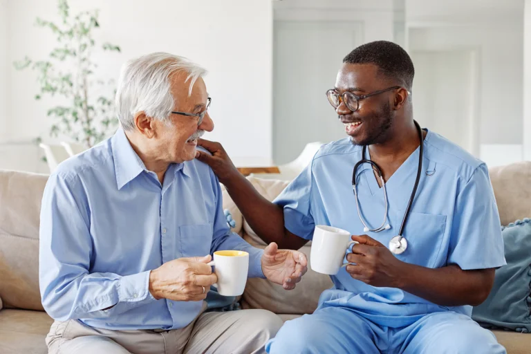 Caretaker drinking coffee with senior resident