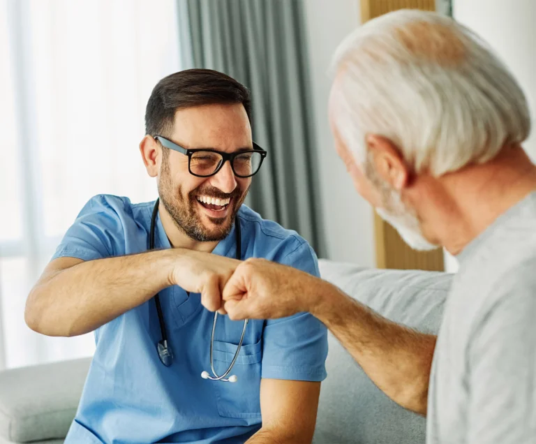 Nurse fist bumping senior patient