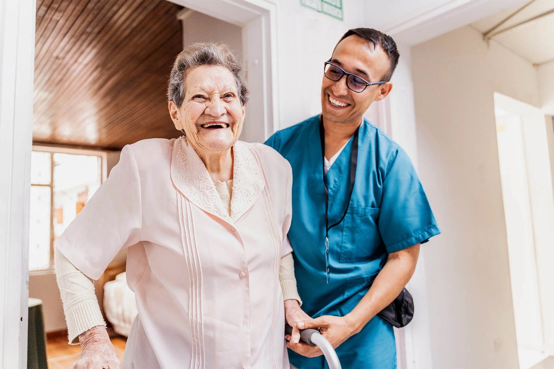 Caretaker helping senior walk using cane