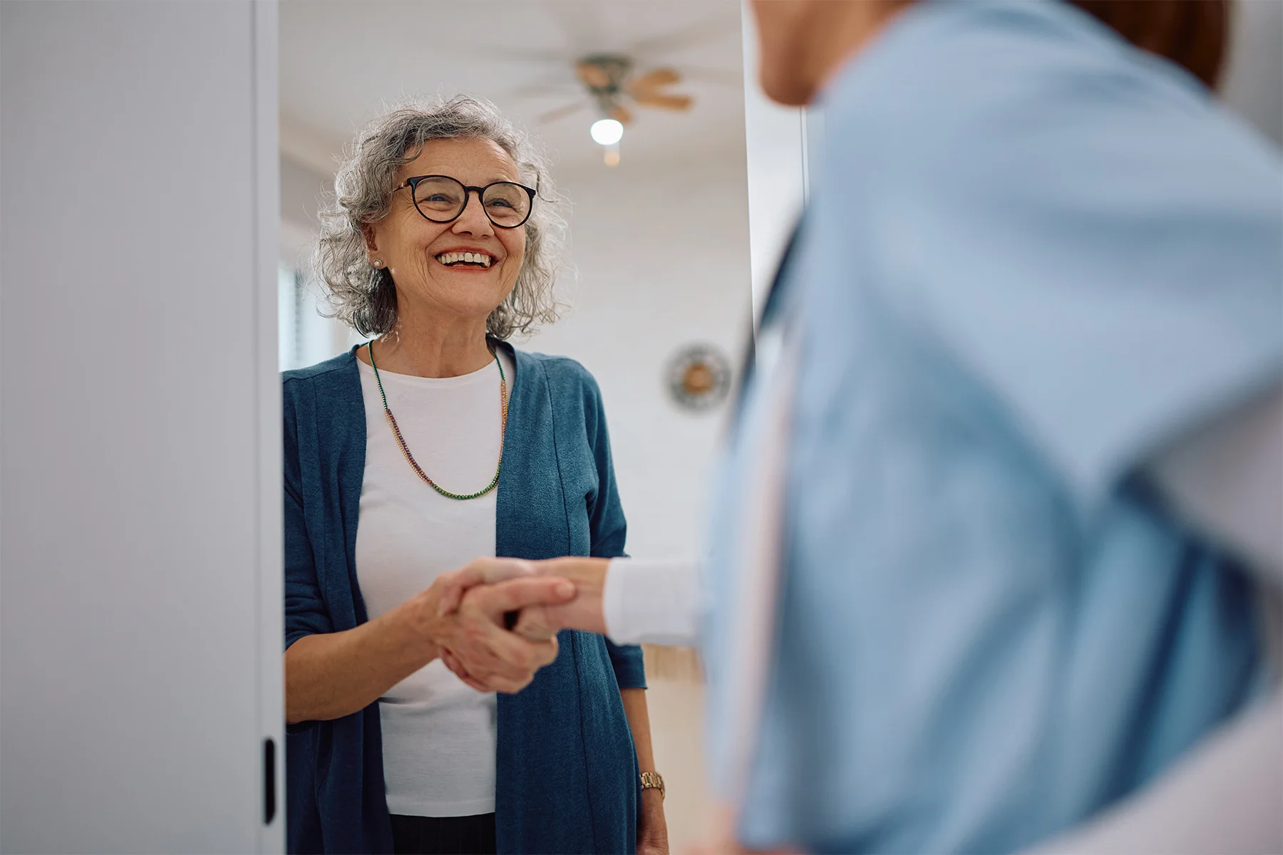 Image of senior woman shaking hands with caretaker